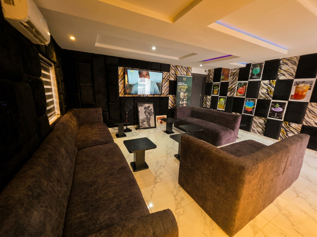 Lounge interior at LAWRENCE LIZ VILLE APARTMENT AND HOTEL in Awoyaya, Ibeju-Lekki — plush seating, ambient lighting and a backlit drink display